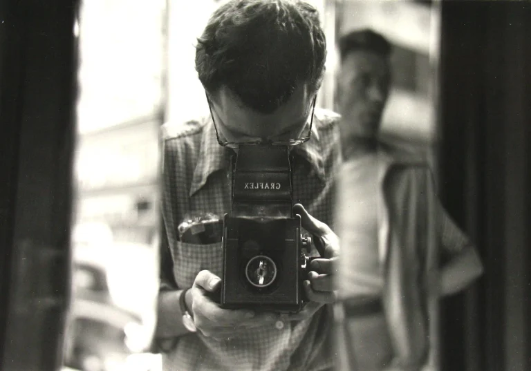 Reflejo en cristal de un fotógrafo con cámara de doble objetivo, fotografía de calle multicapa al estilo de Saul Leiter